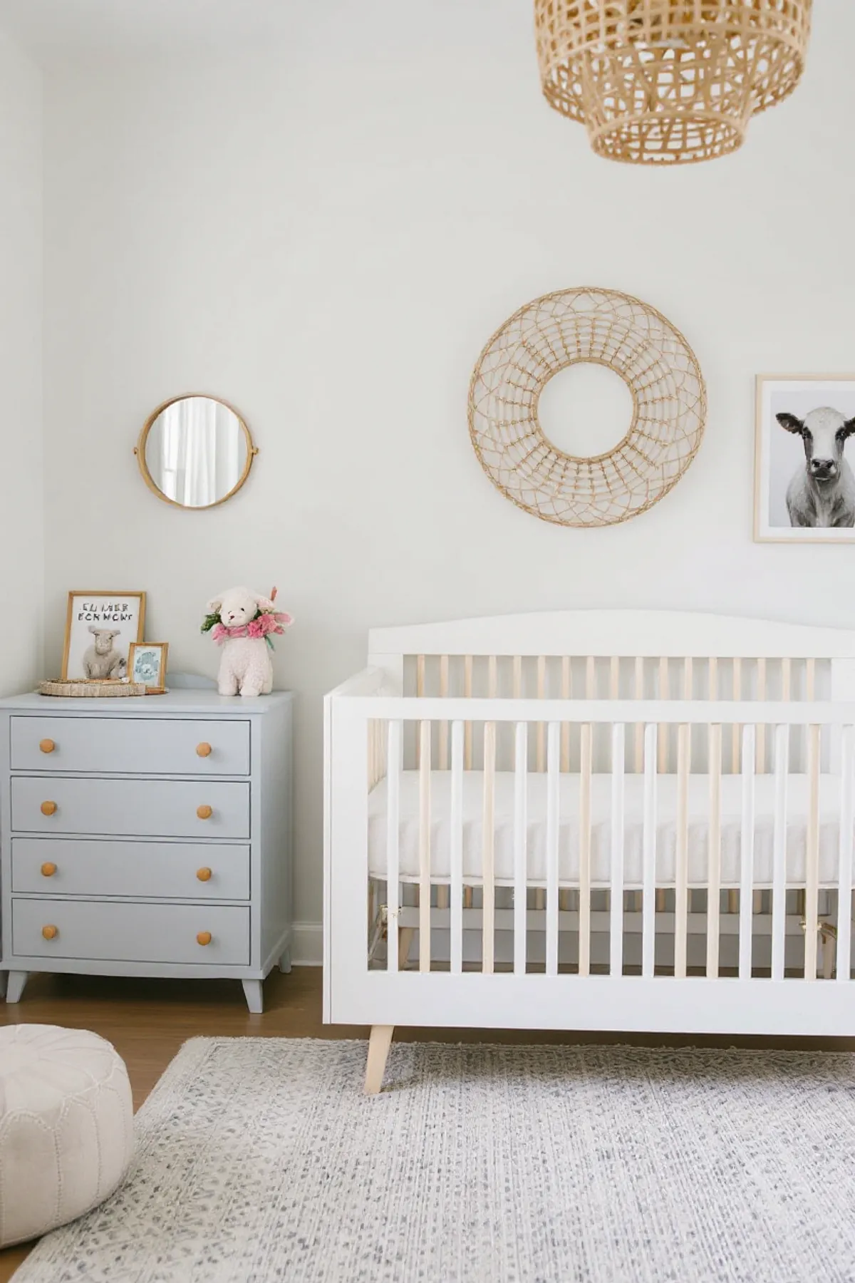 A nursery with a white crib, blue dresser, playful decor, and soft lighting.