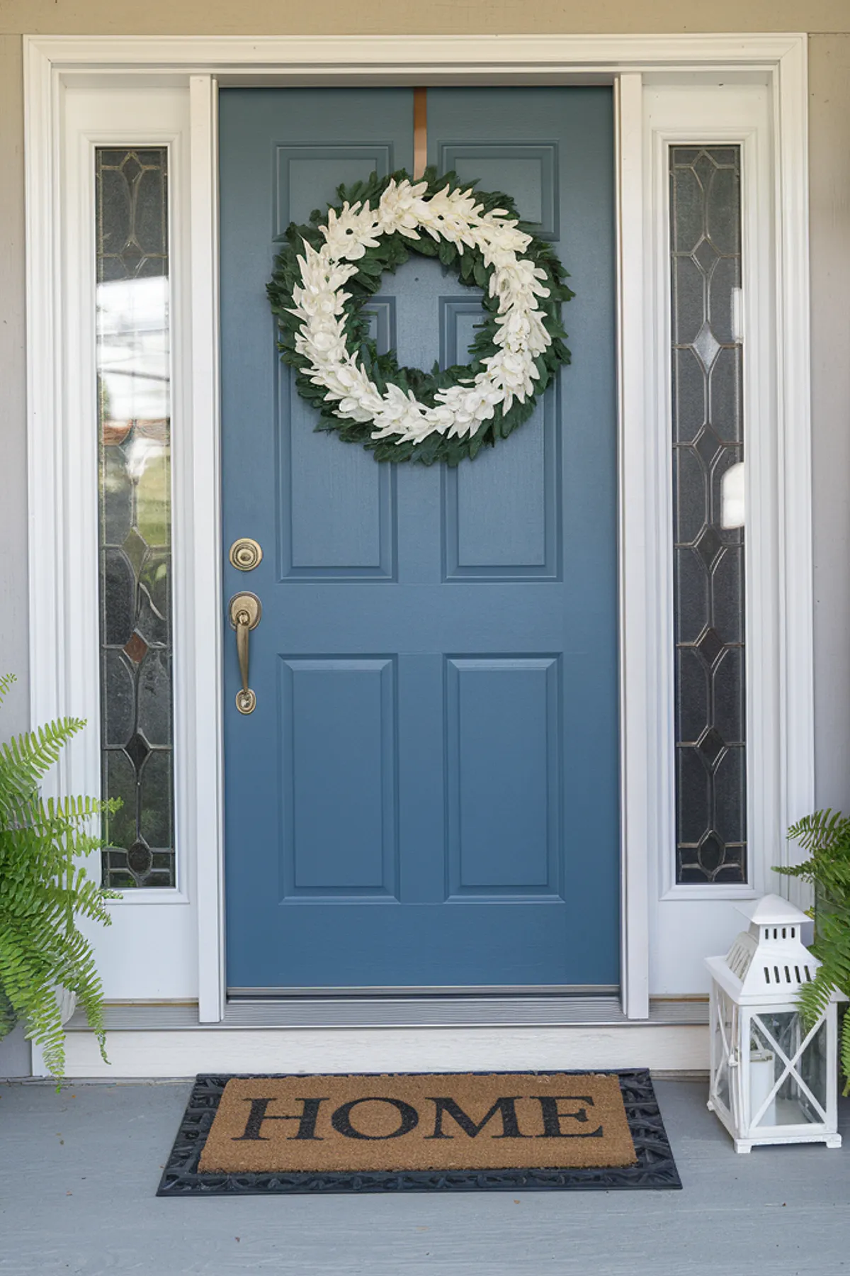 Front porch featuring a blue door with a white floral wreath,
