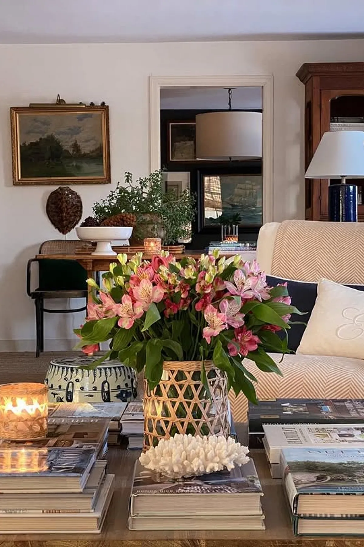Living room featuring a mix of traditional and contemporary decor with a white armchair, wooden furniture, and large window.
