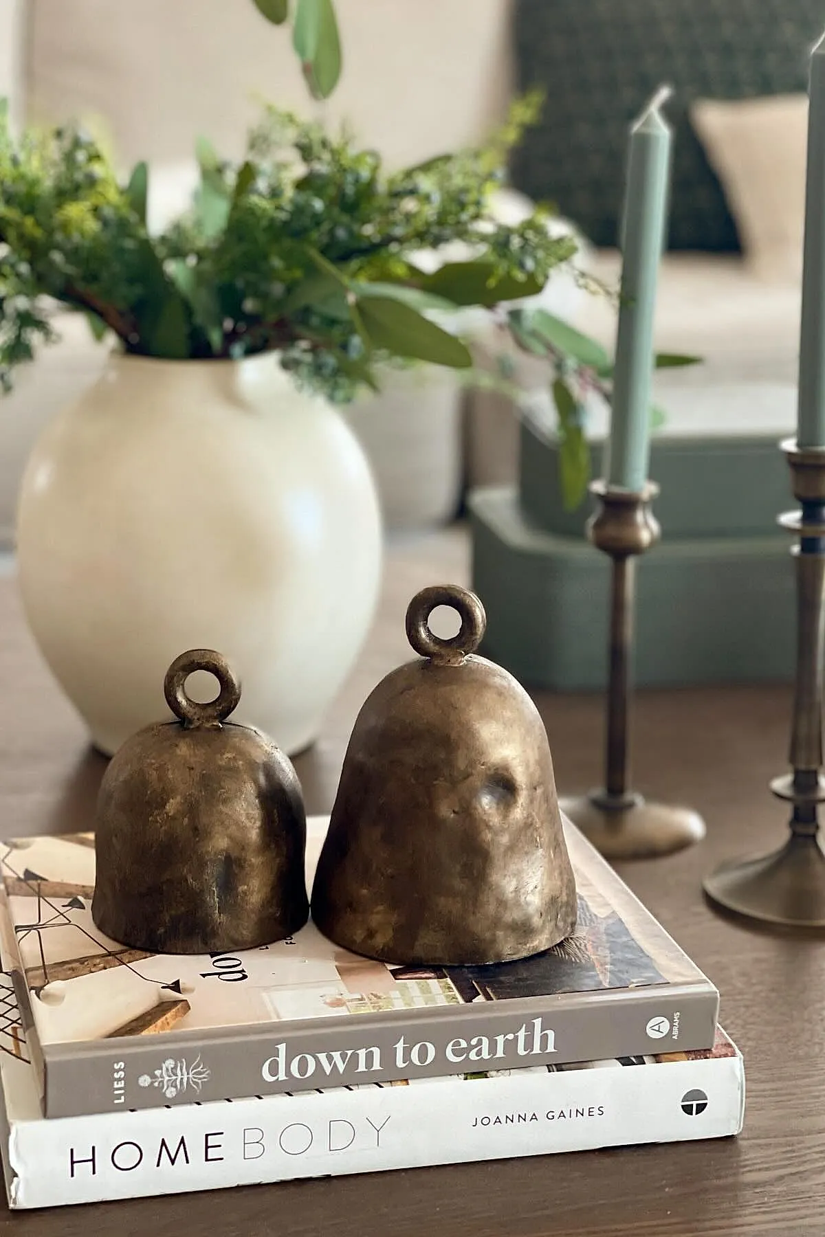 christmas coffee table decor featuring two brass bells placed on top of stacked coffee table books titled